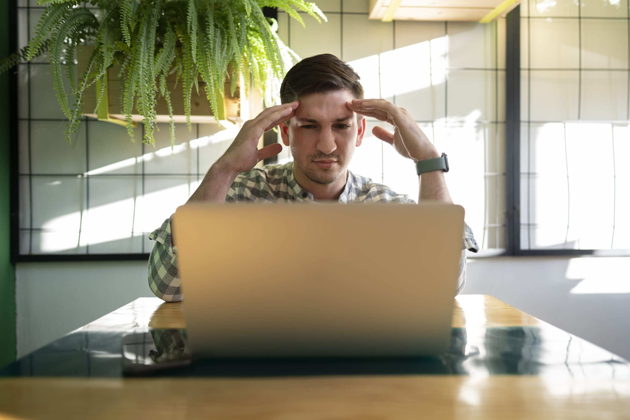 Persona trabajando frente a un ordenador mientras busca información, representando los problemas de navegación confusa en una página web.