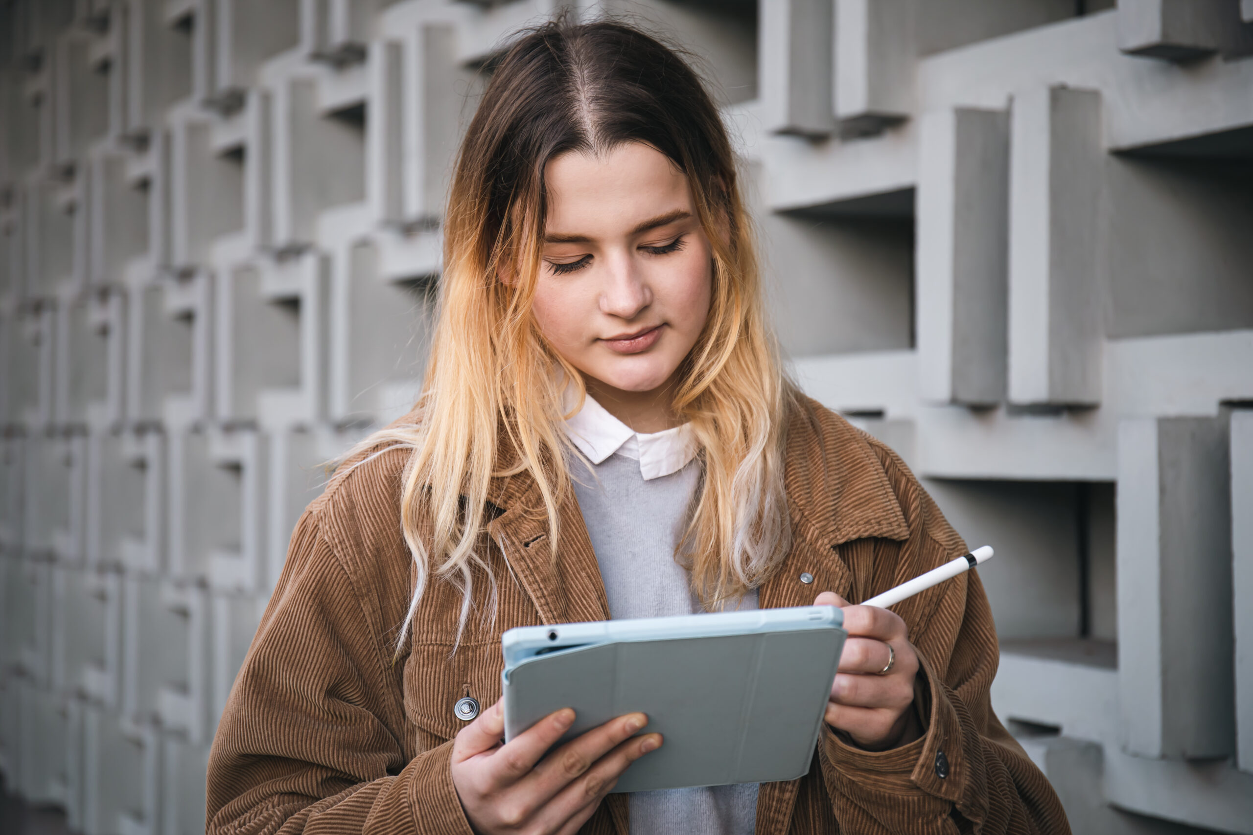 Mujer utilizando una tableta digital para crear y diseñar el contenido de un ebook.