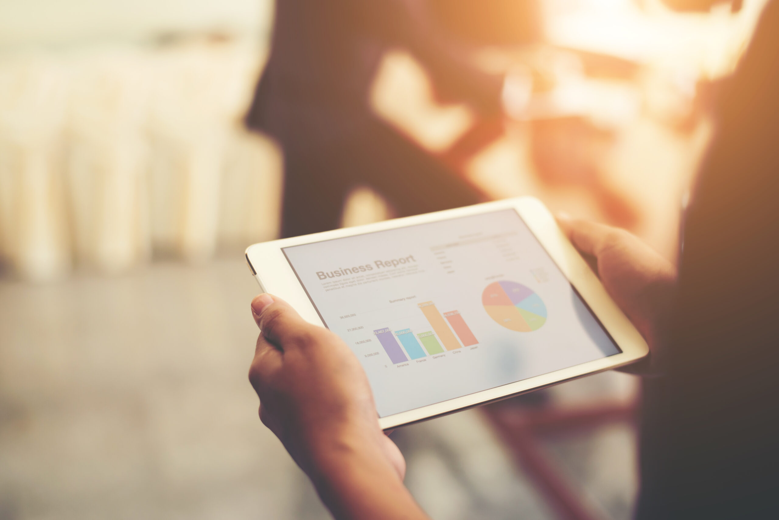 Persona analizando datos en una tableta digital relacionados con ebooks, marketing y rendimiento de contenido.
