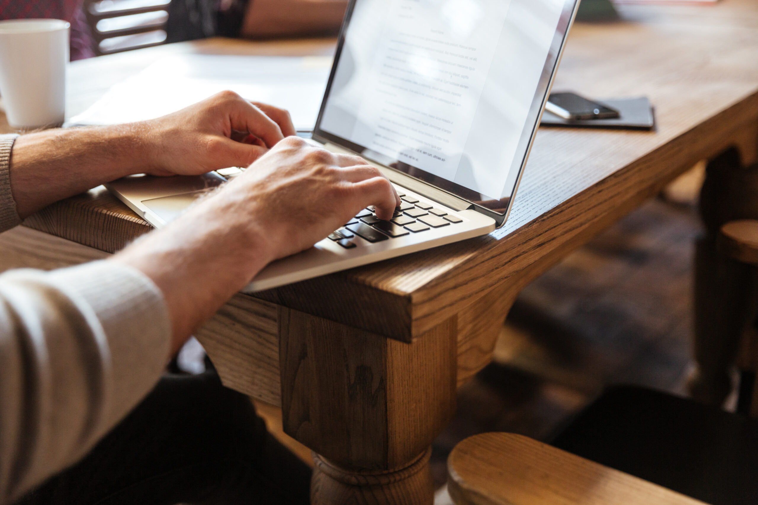 Persona concentrada trabajando con portátil en entorno de coworking, relacionada con copywriting para freelancers.