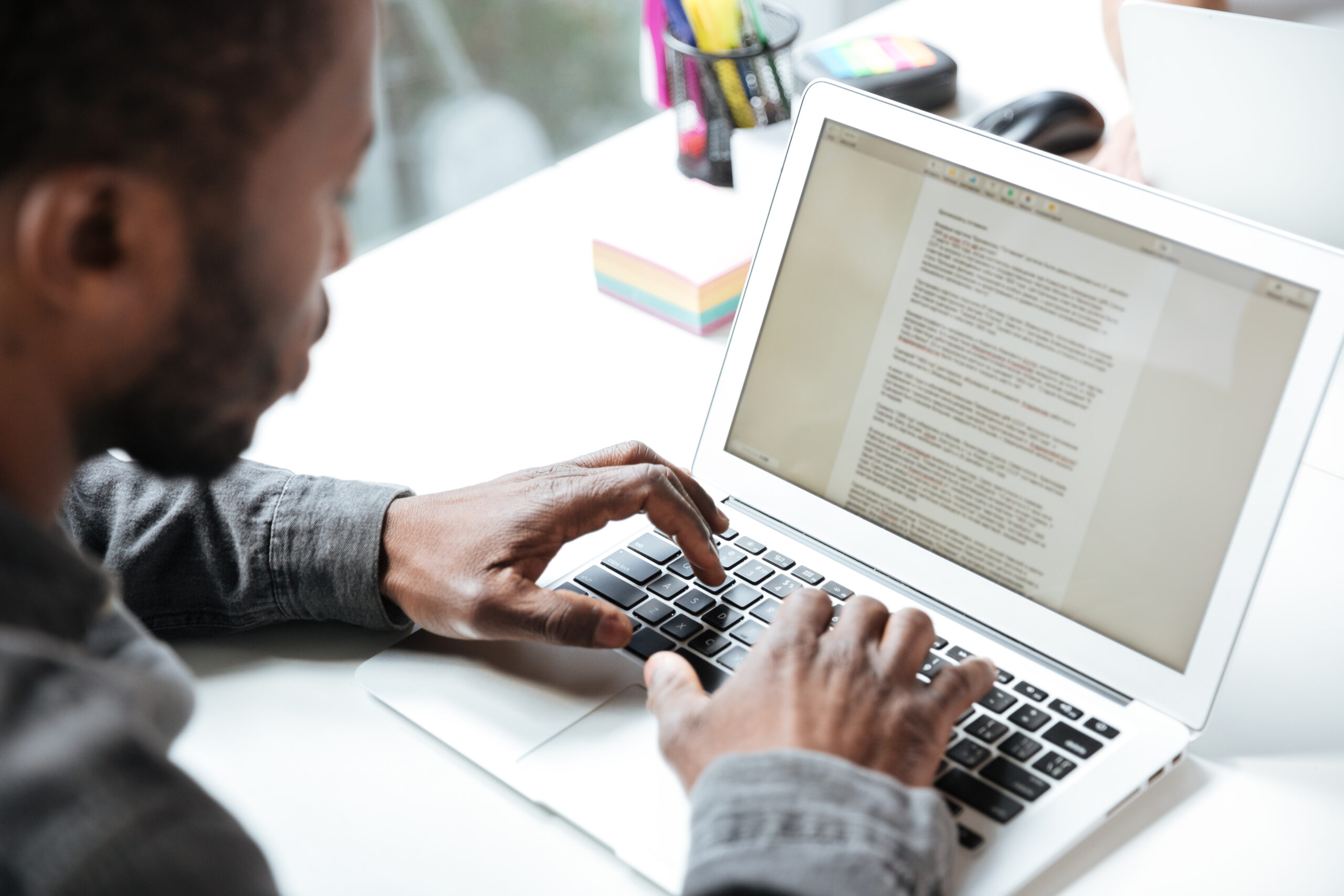 Hombre trabajando en oficina utilizando un ordenador, relacionado con copywriting y creación de contenidos digitales.