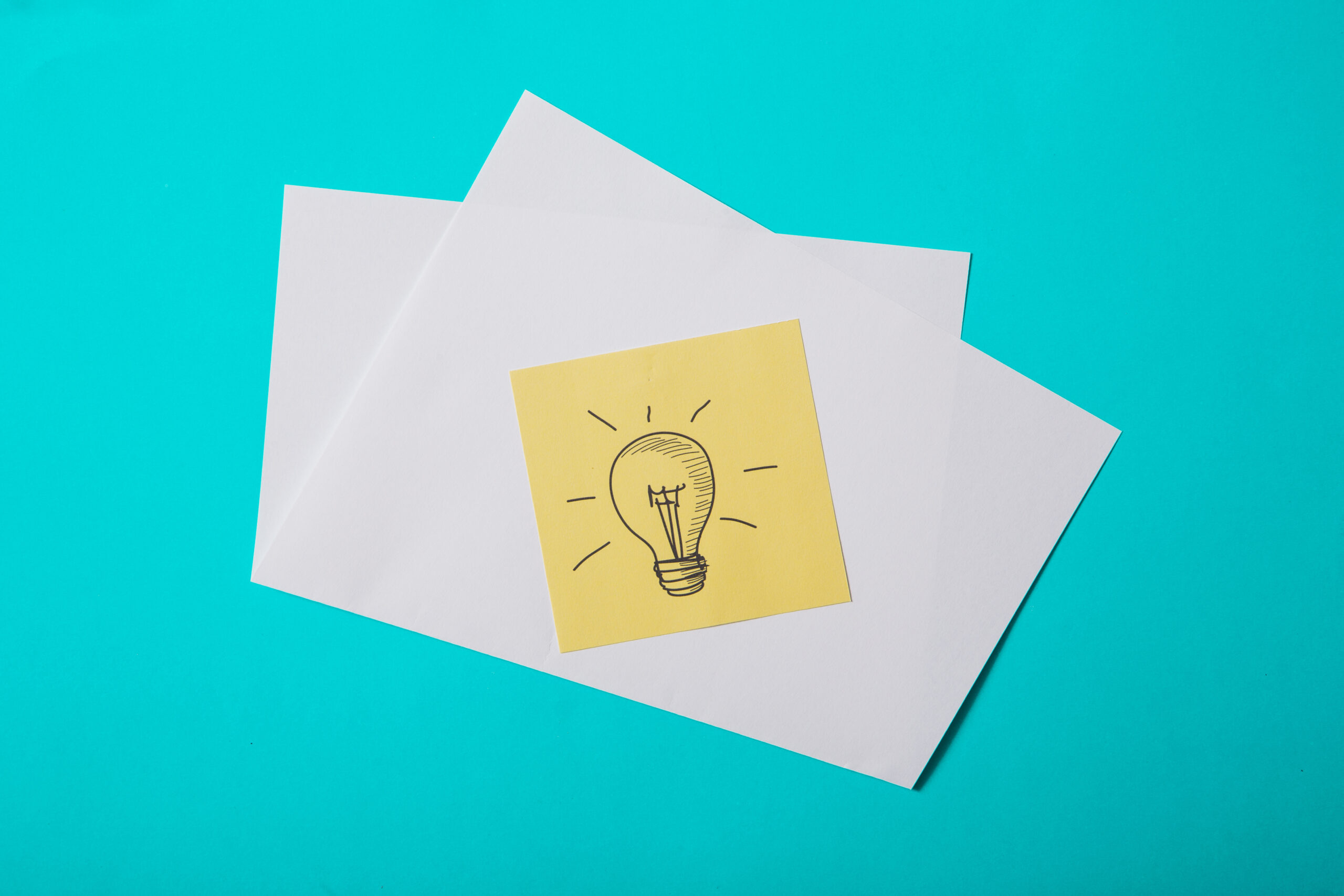 Bombilla dibujada sobre una nota adhesiva amarilla que representa las ideas y las claves para construir un branding sólido.