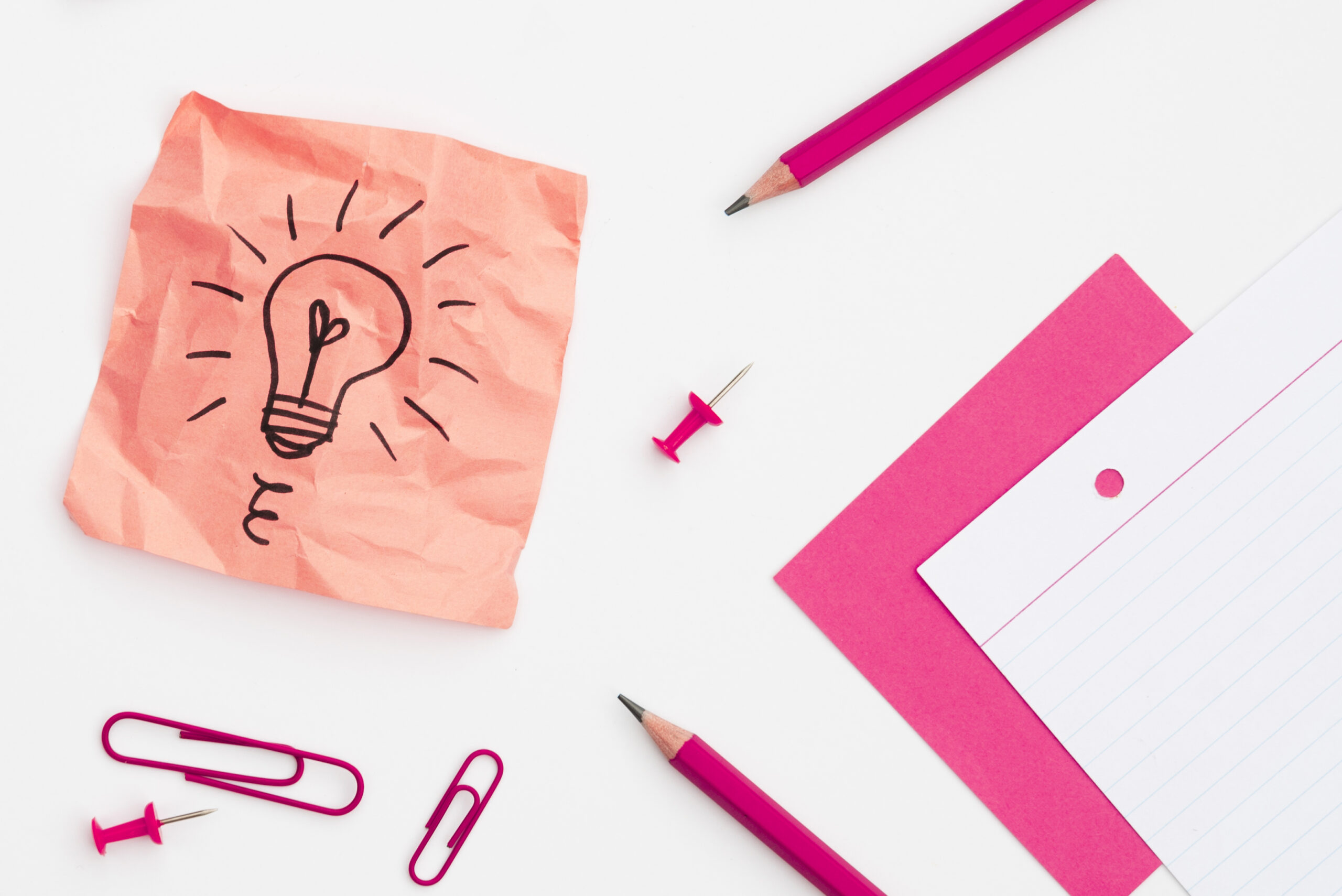 Bombilla dibujada sobre una nota adhesiva rodeada de material de oficina, representando la conclusión sobre el branding y la creatividad empresarial.