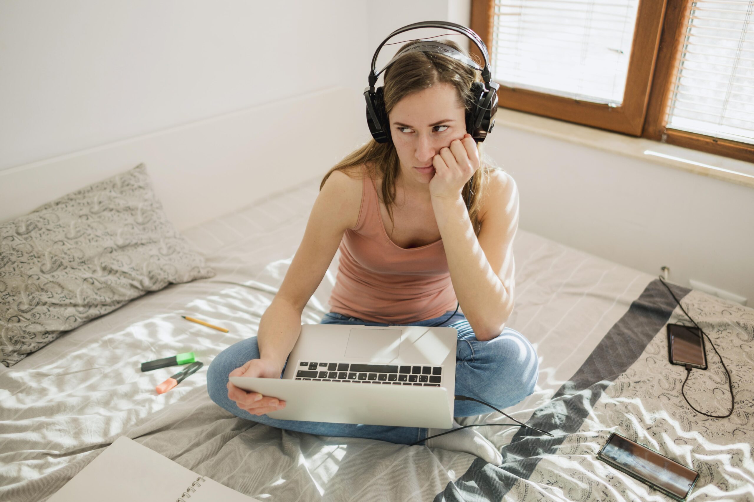Mujer utilizando un portátil y mostrando aburrimiento durante una actividad online, representando una mala experiencia de usuario.