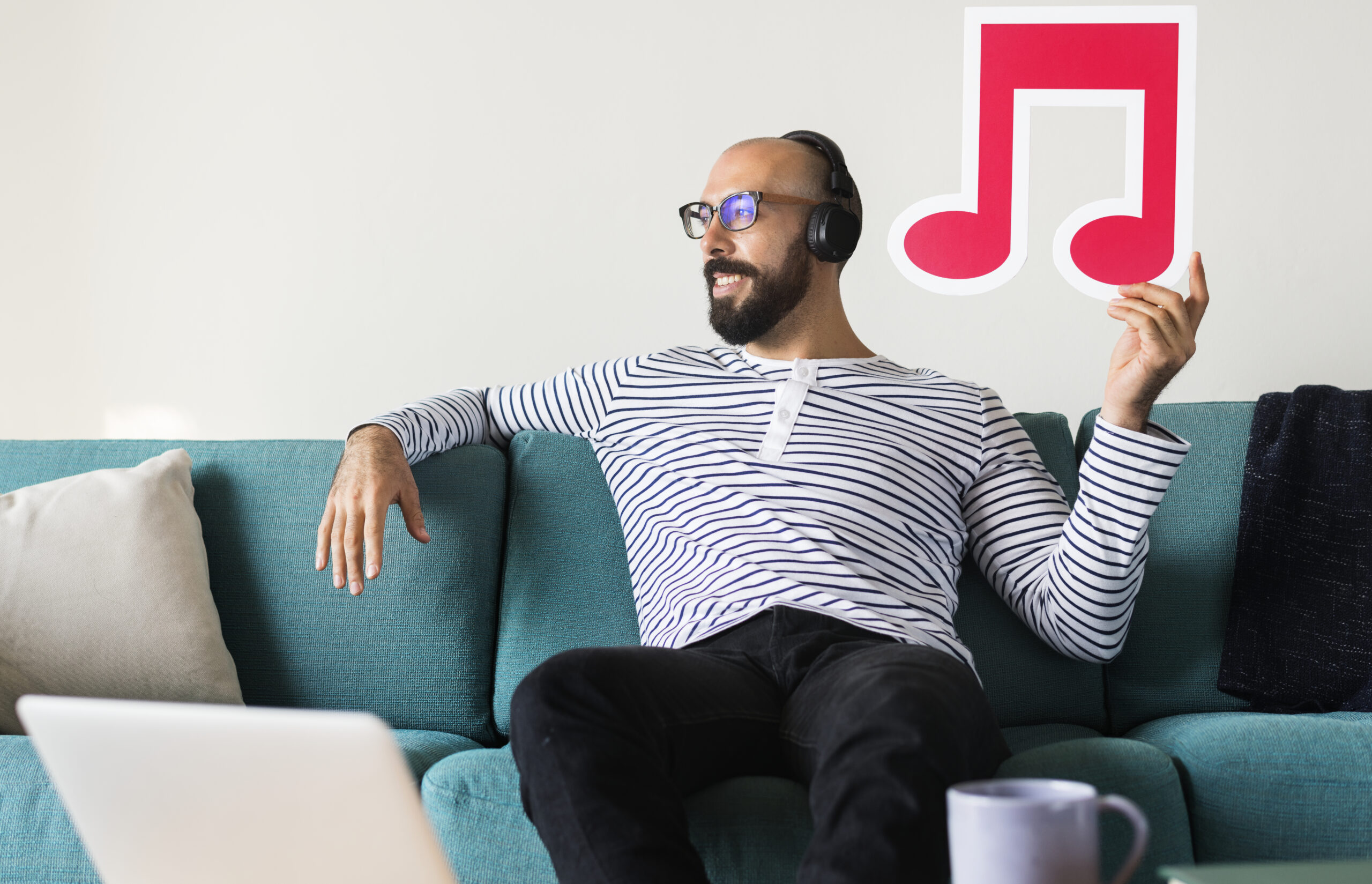 Hombre disfrutando de la música en casa con auriculares, representando la experiencia de audio digital.