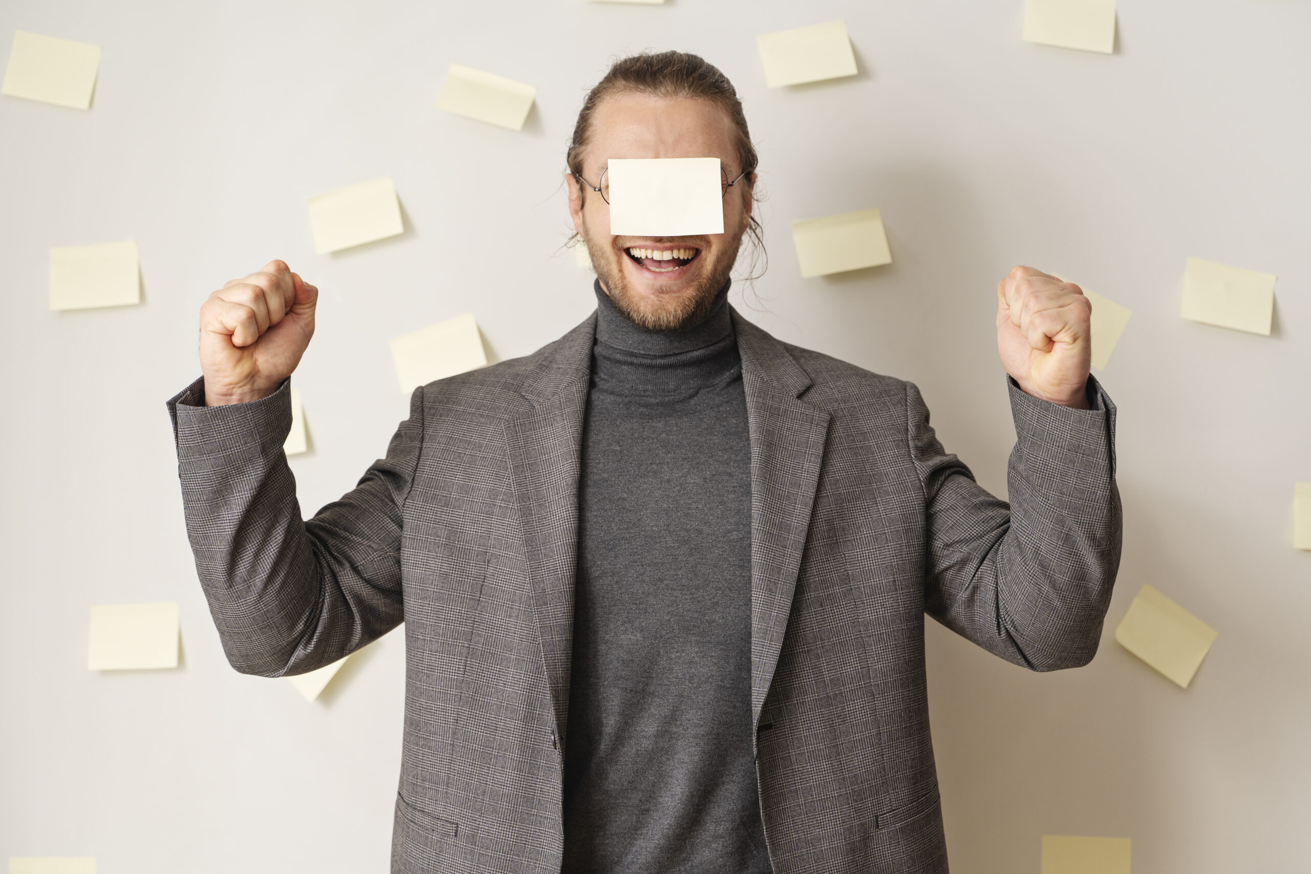 Hombre rodeado de notas adhesivas organizando ideas y tareas para un proyecto digital.