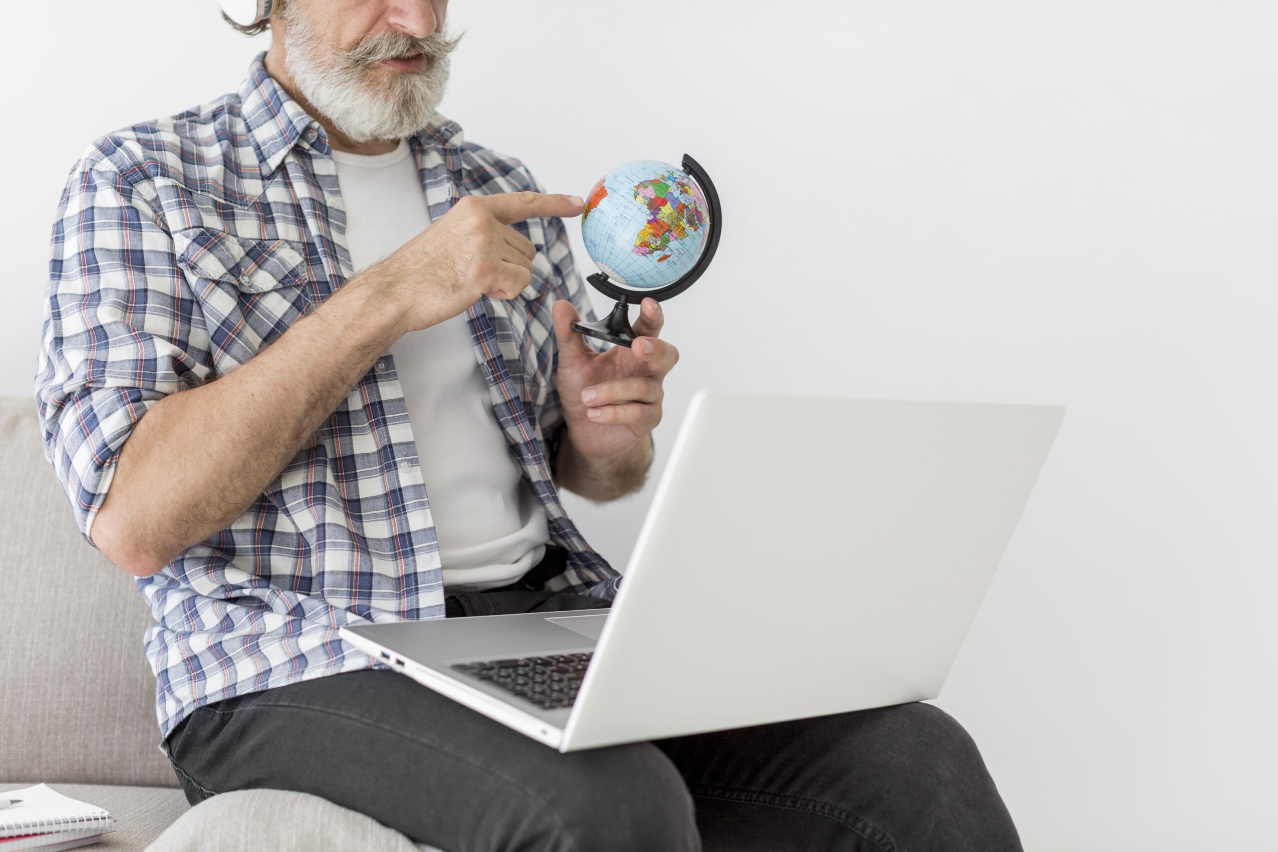 Persona mostrando un globo terráqueo junto a un portátil, relacionado con estrategias de traducción y SEO global.