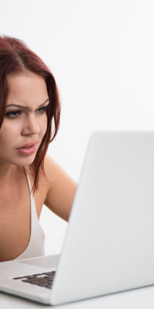 Chica mirando portátil desesperada por errores en su página web