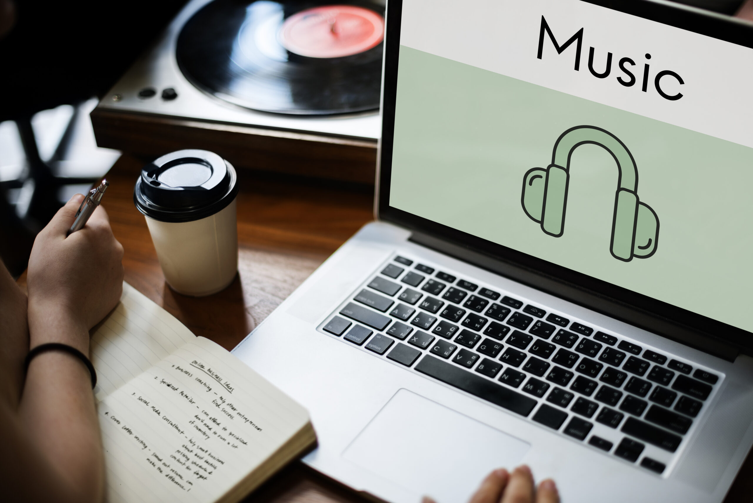 Ordenador portátil con iconos de música y audio que representan el streaming y la reproducción de contenido digital.