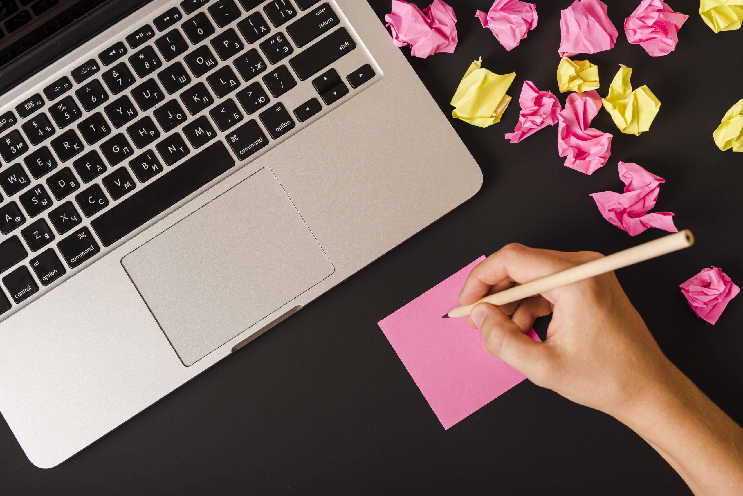 Mano escribiendo notas sobre papel adhesivo, relacionado con planificación de copywriting y estrategia de contenido.