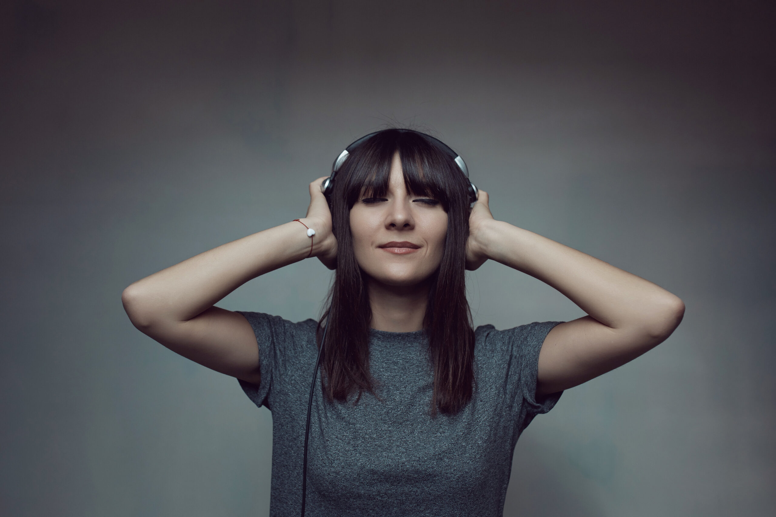 Mujer reaccionando al sonido con expresión emocional, representando el impacto del audio en la percepción.