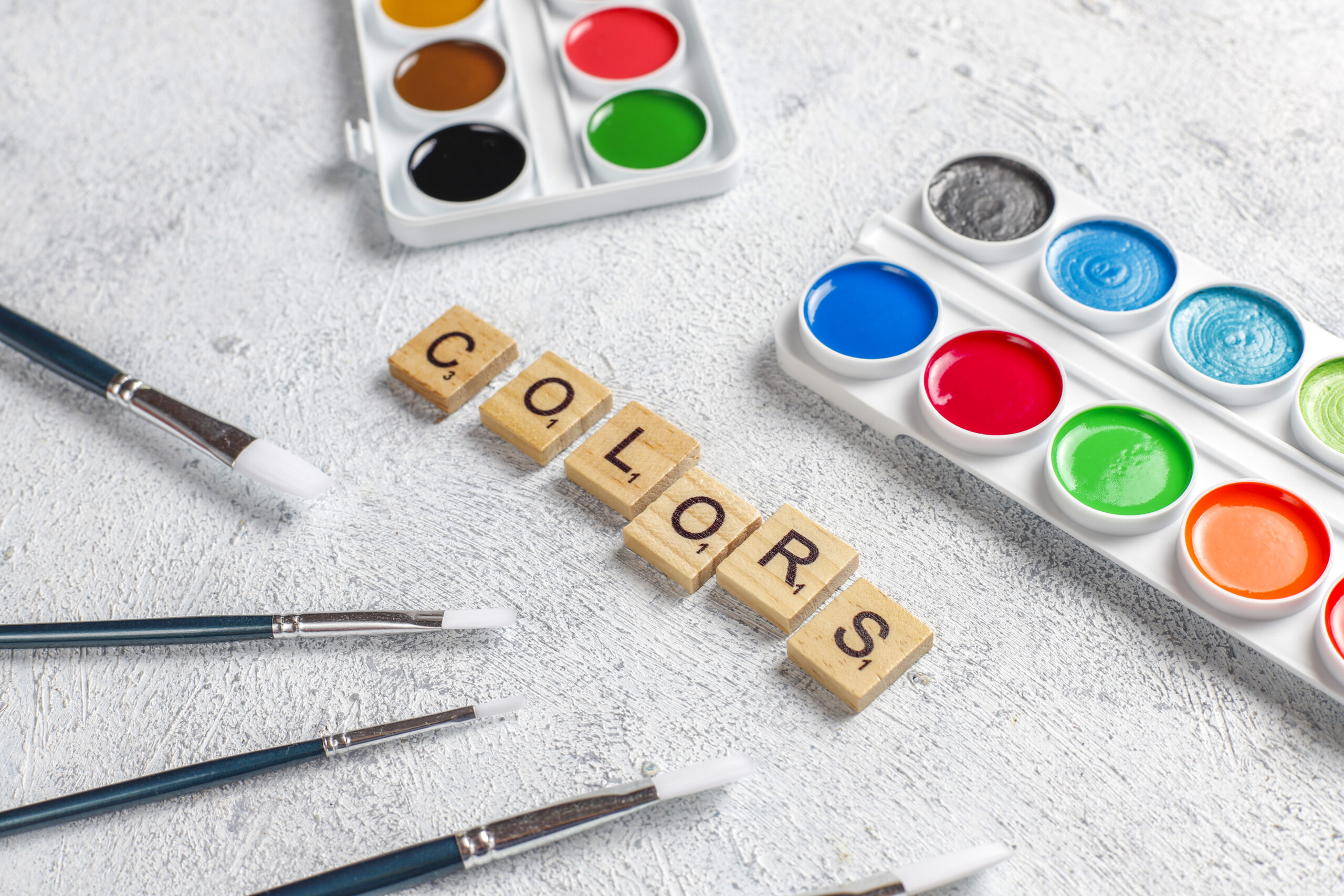 Paleta de acuarelas y pinceles que representan la importancia del color en el diseño y la identidad de una marca.