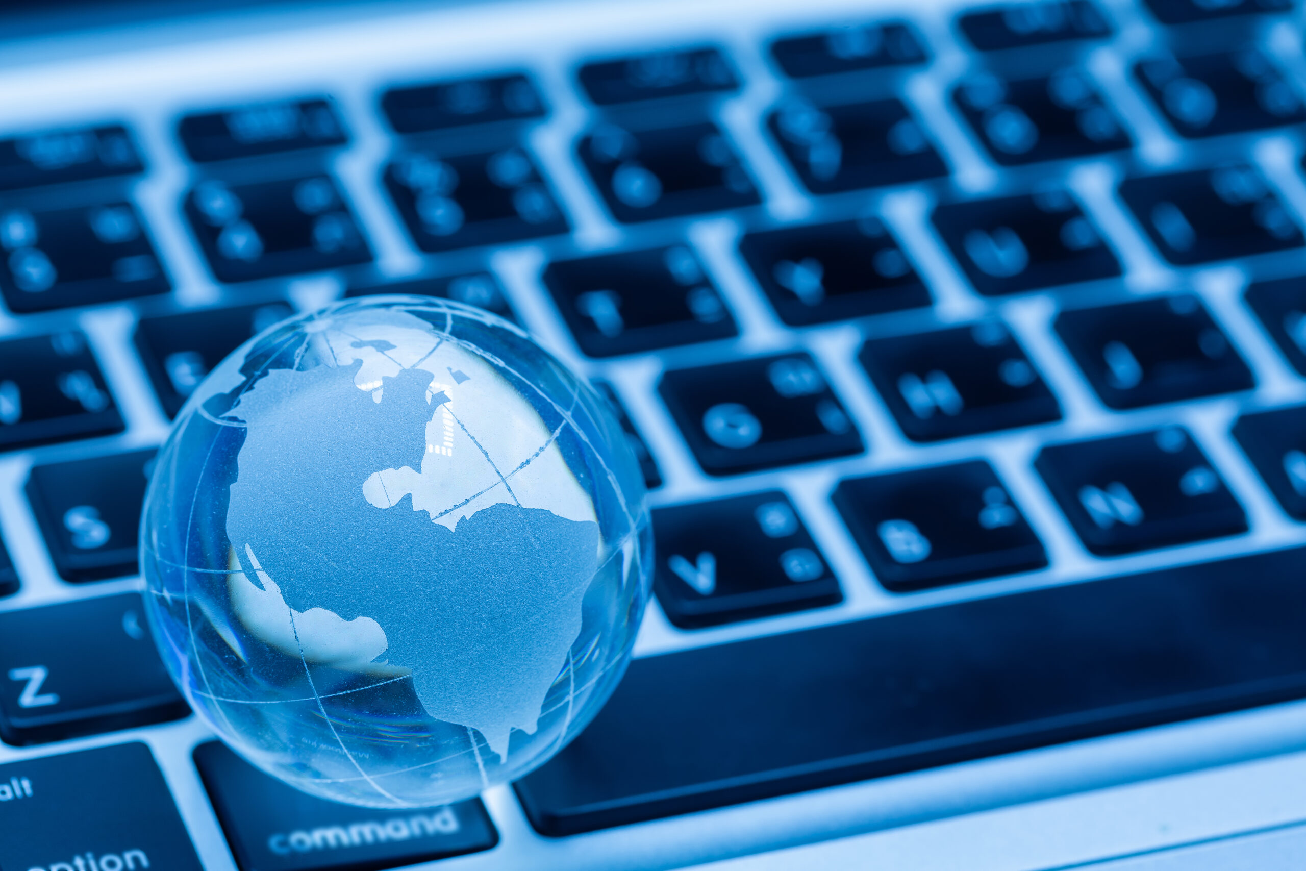 Globo terráqueo junto a teclado de ordenador, representando conectividad global y tecnología digital.
