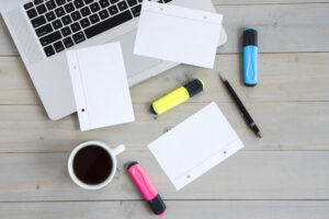 Escritorio de trabajo con ordenador portátil, dispositivos digitales y material de oficina para la planificación de proyectos empresariales y branding.