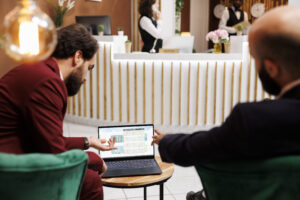 Personas reunidas en un hotel moderno utilizando dispositivos digitales durante una reunión de trabajo.