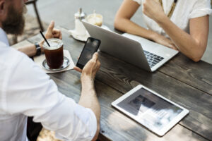 Persona utilizando un teléfono móvil en una mesa de una cafetería o restaurante.