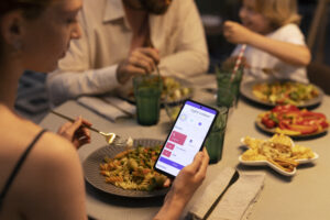 Cliente reservando una mesa en un restaurante desde el teléfono móvil.