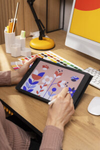 Diseñador gráfico trabajando en el diseño de una portada de libro profesional desde un estudio creativo.